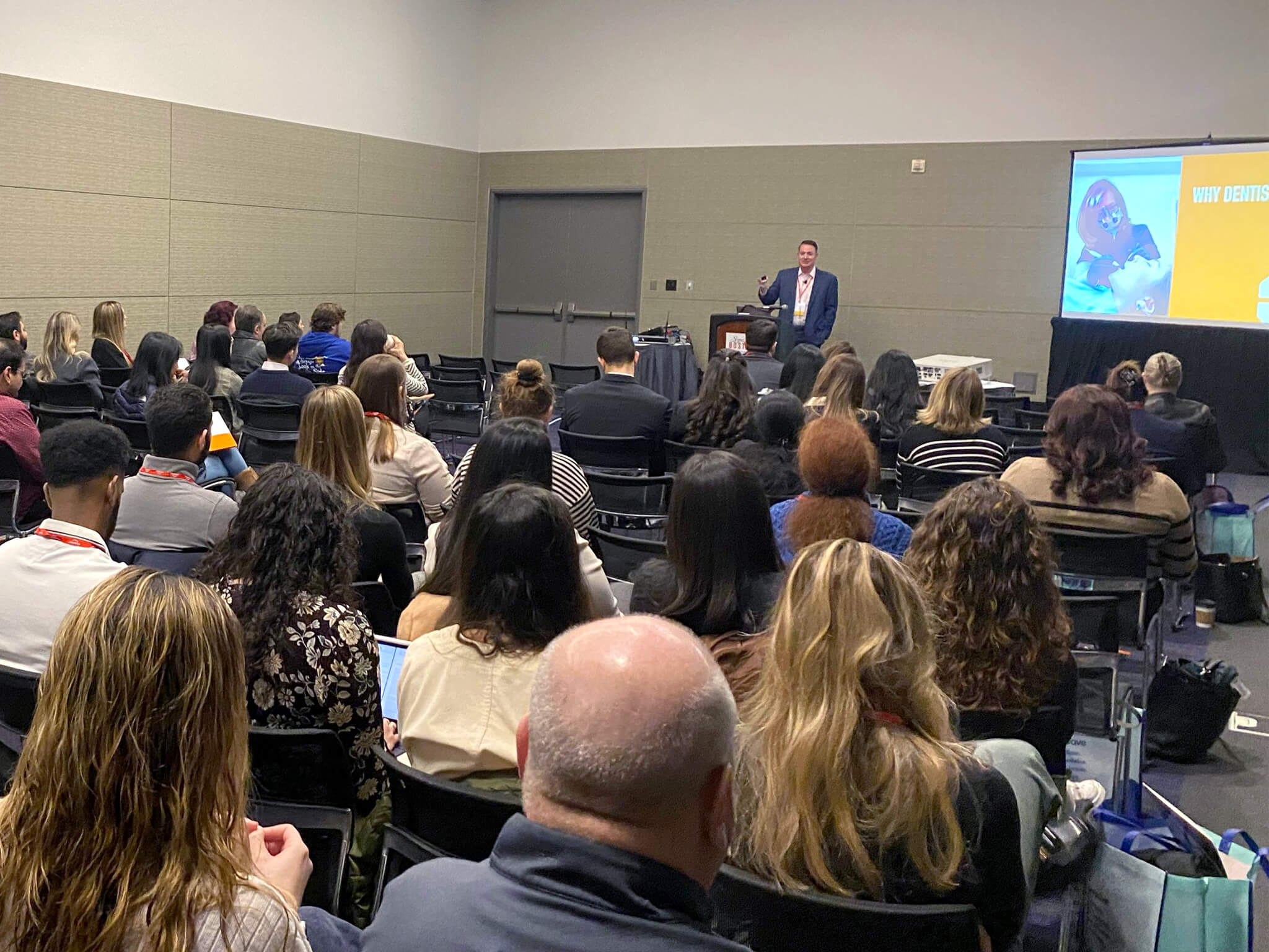 Casey Hiers presenting to a room full of dentists at a conference.